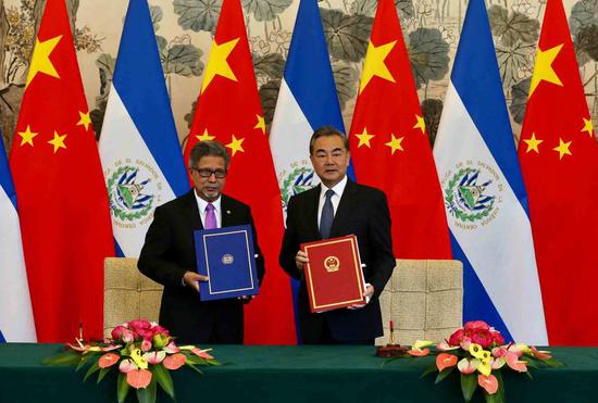 Chinese State Councilor and Foreign Minister Wang Yi and EL Salvador Foreign Minister Carlos Castaneda sign a joint communique on the establishment of diplomatic relations in Diaoyutai State Guesthouse in Beijing on Tuesday. (Photo by Xu JingXing/China Daily)