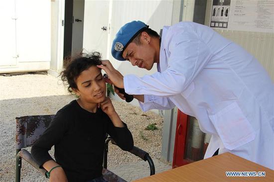 A Chinese peacekeeper gives a health examination for local people in Beirut, Lebanon, Aug. 19, 2018. Peacekeepers in Lebanon carried out a free clinic on Sunday, China's first Medical Workers' Day, winning praises from local residents. (Xinhua/Yang Shuangquan)