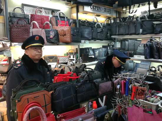 Officers from the Dongcheng district branch of the Beijing Administration for Industry and Commerce launch investigations during Spring Festival in an effort to combat the sale of counterfeits. (Photo by Pei Qiang and Niu Jing/for China Daily)