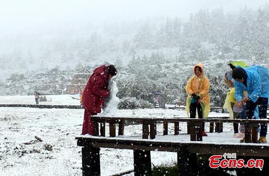 Visitors enjoy view of snow at Daocheng Yading scenic spot in Ganzi Tibetan Autonomous Prefecture of southwest China’s Sichuan province on September 20, 2016. (File photo/China News Service)