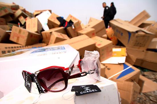 Officers from the Chengguan district branch of the Lanzhou Administration for Industry and Commerce in Gansu province destroy counterfeit goods they seized last year. (Photo by Pei Qiang and Niu Jing/for China Daily)