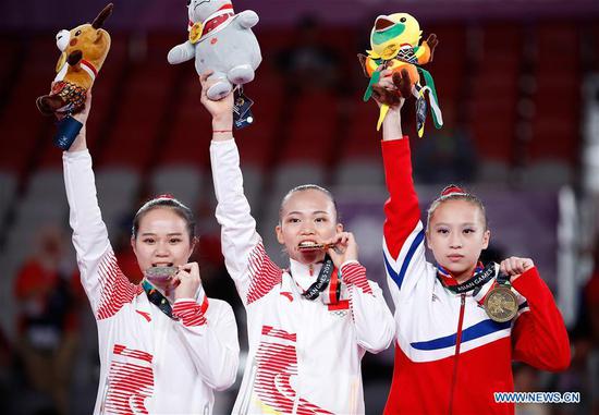 Gold medalist Chen Yile (C) of China poses with silver medalist Luo Huan (L) of China and bronze medalist Kim Su Jong of the DPRK during the awarding ceremony for Artistic Gymnastics Women's Individual All-Around Final at the Asian Games 2018 in Jakarta, Indonesia on Aug. 21, 2018. (Xinhua/Wang Lili)