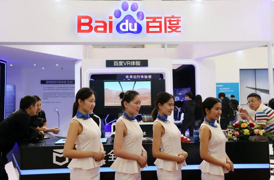 Baidu employees pose for a photograph at the company's booth during a high-tech exhibition in Beijing. (Photo by A Qing/For China Daily)