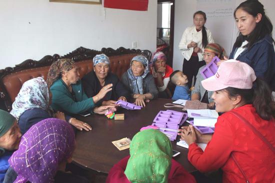 Members of the workshop attend a group meeting. (China Daily)