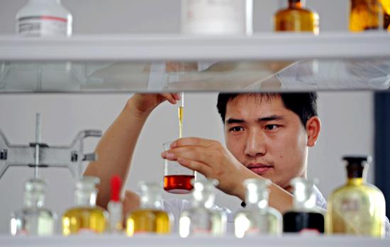 A researcher tests a biofuel made from cooking oil in Shangrao, Jiangxi province. (Photo/Xinhua)