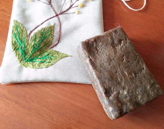 A piece of black soap and its packing bag made by Kazakh women in a soap-making workshop in Qinghe county, in the Xinjiang Uygur autonomous region. (Photo/China Daily)