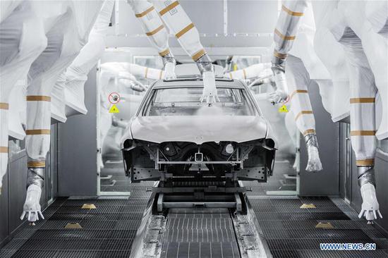 This undated photo shows a car being painted by robots at a factory of BMW in Shenyang, capital of northeast China's Liaoning Province. (Xinhua)