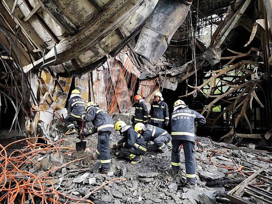 Firefighters conduct rescue operations in the ruins of the Beilong Hot Spring Hotel in Harbin, Heilongjiang Province, on Saturday. (Photo by XIAO JINGBIAO/FOR CHINA DAILY)