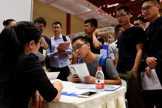 Young people seek employment opportunities at a job fair in Chongqing that attracted companies from the technology, internet and finance sectors, among others. (ZHOU YI/CHINA NEWS SERVICE)