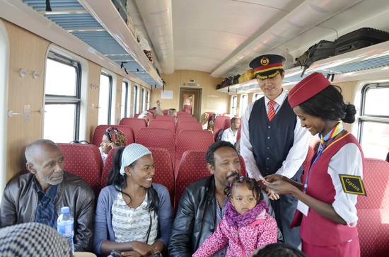 A captain checks tickets on a train running on the Chinese-built Addis Ababa-Djibouti Railway, the first modern electric railway in Africa, which was put into operation in January. (Photo/Xinhua)