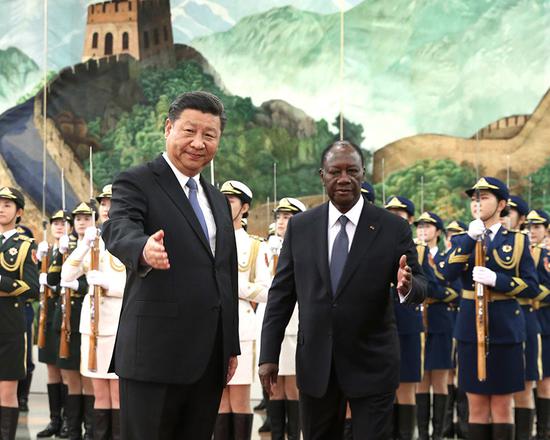 President Xi Jinping accompanies Cote d'Ivoire President Alassane Ouattara in the Great Hall of the People in Beijing on Thursday. (Photo by Feng Yongbin/China Daily)