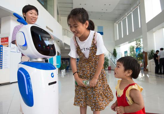 A robot helps with services at an outlet of China Construction Bank Corp in Nantong, Jiangsu Province. (Photo by Xu Jinbo/For China Daily)