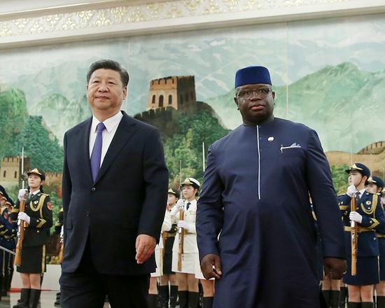 President Xi Jinping walks with Sierra Leonean President Julius Maada Bio in the Great Hall of the People in Beijing on Thursday. (Photo by Wang Zhuangfei/China Daily)