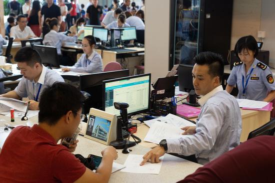 A staff member serves a customer at an enterprise service center in Pudong New Area, Shanghai, Aug. 28, 2018. (Photo by Gao Erqiang/chinadaily.com.cn)