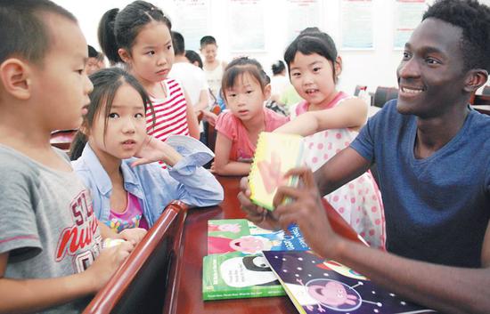 A student from the DRC volunteers to teach English in a village school in Jiangsu province. (Shi Yucheng / For China Daily)