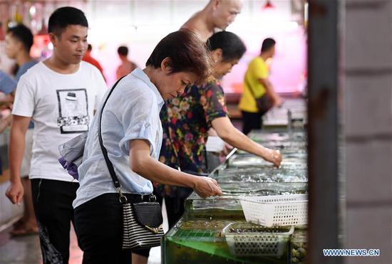 Customers buy seafood in a market in Nanning, South China's Guangxi Zhuang autonomous region, June 9, 2018. (Photo/Xinhua)