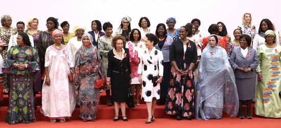 Peng Liyuan, wife of President Xi Jinping, and wives of African heads of state and government gather for a photo on Tuesday in Beijing. At a meeting on the same day, they launched an initiative by China and Africa to combat HIV/AIDS. (ZOU HONG / CHINA DAILY)