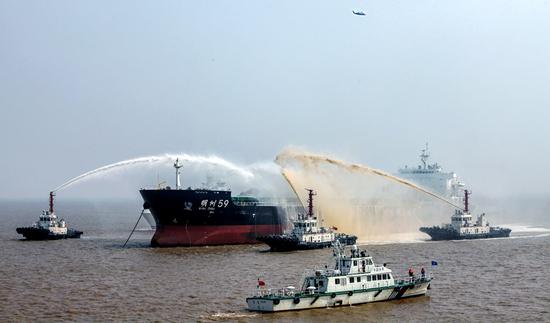 Rescue ships spray an oil tanker with fire-extinguishing chemicals to battle a simulated fire during a drill off Zhoushan, Zhejiang province, on Tuesday. (Photo by Hua Zhibo/for China Daily)