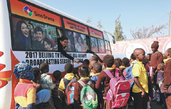 Children at Chawama, Zambia, welcome the mobile film van on July 11, 2017. (Photo provided to China Daily)