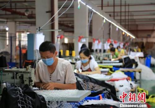 Employees work at a manufacturing plant.  (Photo/China News Service)