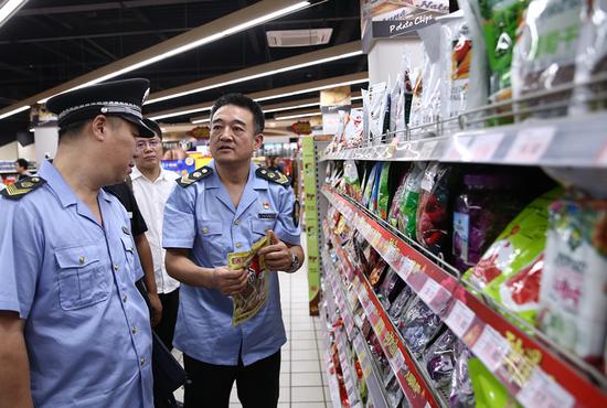 Inspectors check the food quality at a supermarket in Beijing's Xicheng district on Oct 9, 2019. (Zou Hong/China Daily)