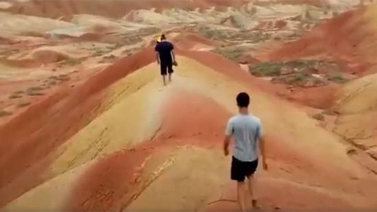 Two men walk on the Danxia landform. /Screenshot