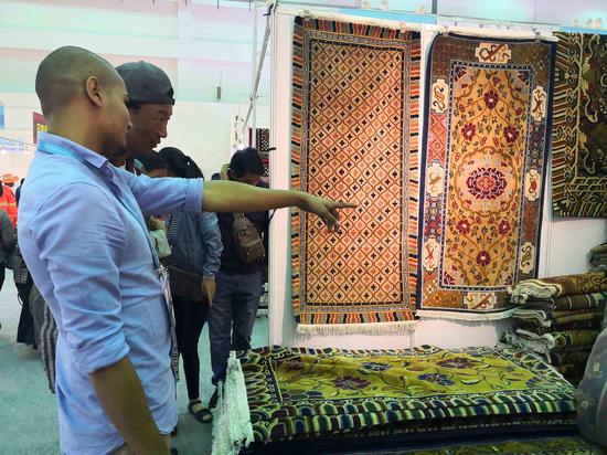 Nepali businessmen promote their carpets at the 4th China Tibet Tourism and Culture Expo on September 8, 2018, in Lhasa, Tibet Autonomous Region.(Photo by CGTN)