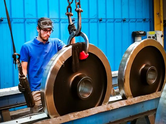 A worker of Valdunes, a French high-speed train wheel manufacturer, repackages the Ma Steel high-speed train wheels to be shipped to Germany. （Photo provided to China Daily）