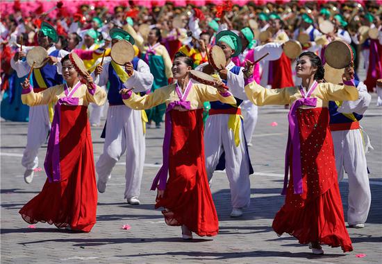 Dancers perform at a parade in Pyongyang on Sunday to commemorate the 70th anniversary of the founding of the Democratic People's Republic of Korea. (Photo/Xinhua)