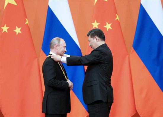 President Xi Jinping awards his Russian counterpart Vladimir Putin the first-ever Friendship Medal of the People's Republic of China at the Great Hall of the People in Beijing, June 8, 2018. (Photo/Xinhua)