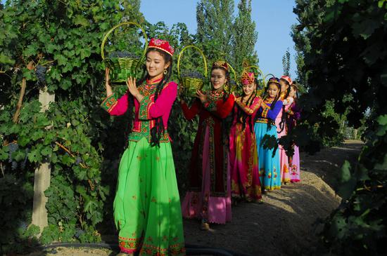 Women dressed in colorful outfits perform at the 27th Silk Road Turpan Grape Festival in Turpan, Northwest China's Xinjiang Uygur autonomous region, Sept 3, 2018. (Photo provided to Chinadaily.com.cn)