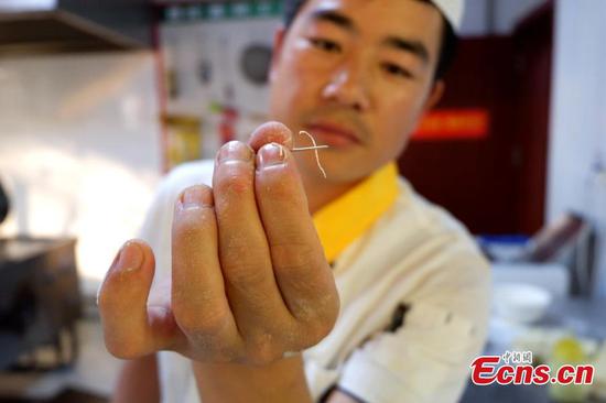 Lamian cook makes noodle thin enough to thread a needle