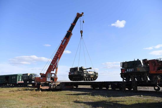 An armored infantry vehicle is being loaded onto a train. (Photo： CGTN/Yang Zaixin)