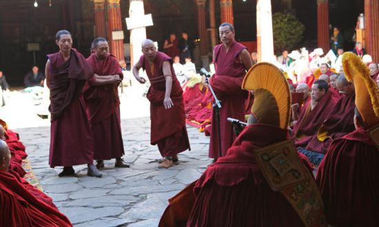 Monks participate in dharma debates in the Jokhang Temple, Lhasa, capital city of Tibet autonomous region. (Photo by Palden Nyima/China Daily)