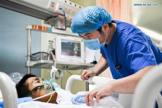 Nurse Liu Xiangda (R) checks a patient in the intensive care unit (ICU) of Zhengzhou Central Hospital in Zhengzhou, capital of central China's Henan Province, May 9, 2017. (Xinhua/Li Bo)