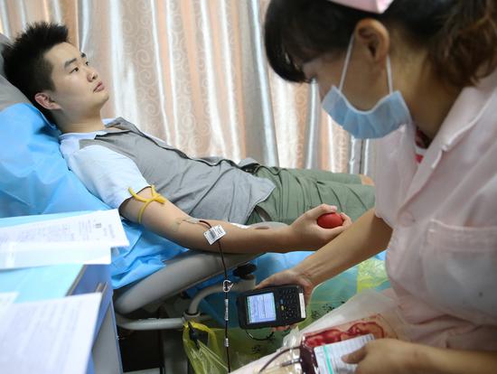 A student from the University of South China donates blood in Hengyang, Hunan province, on Thursday. The city has called for the public to donate for people injured in a deadly attack in Hengdong county on Wednesday. Eleven people have died and 44 were injured in the automobile and knife attack. (CAO ZHENGPING/FOR CHINA DAILY)