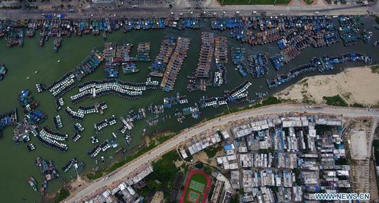Aerial photo taken on Sept. 14, 2018 shows fishing boats returning to harbor at a fishing port in Sanya, south China's Hainan Province. Mangkhut, the 22nd typhoon this year, is expected to land in south China's Guangdong and Hainan provinces on the night of Sept. 16. (Photo/Xinhua)
