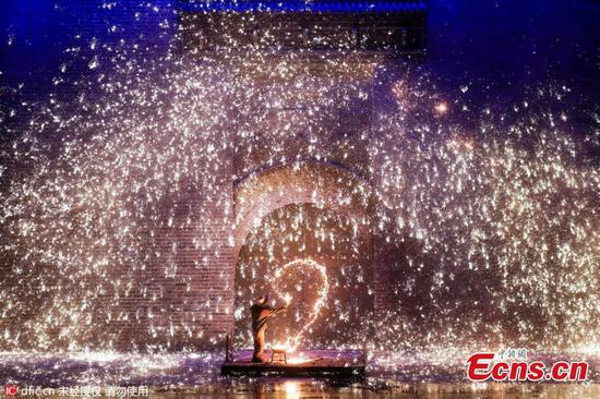 A man sprays molten iron against a cold concrete wall to form sparks like fireworks to celebrate a wedding anniversary in Yuxian County, North China’s Hebei Province. The county has a hundreds of years of history of carrying out the tradition of spraying molten iron against a cold concrete wall to form sparks like fireworks. The husband said he wanted to make up for the lack of a wedding ceremony when they got married 20 years ago. (Photo/IC)