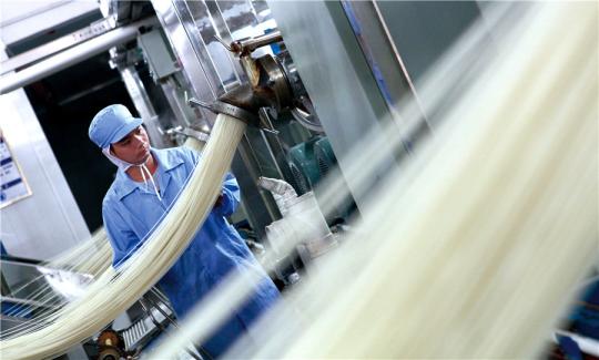 A staff member supervises the production process at the company's mill. （DARA WANG/CHINA DAILY）