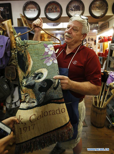 Steve Taylor, who runs a small grocery for 16 years, shows a scarf made in China in his store in Estes Park, a small town located at the foothill of Rocky Mountain in north Colorado, the United States on Sept. 21. 2018. Estes Park is a popular summer resort attracting tourists from all of the world, and most of products in shops there are labeled 