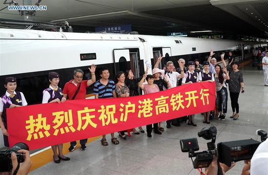 Passengers of train G99 pose for a group photo at Hongqiao Railway Station in Shanghai, east China, Sept. 23, 2018. Train G99, the first high-speed train from Shanghai to Hong Kong, left Hongqiao Station on Sunday for Hong Kong West Kowloon Station. (Xinhua/Chen Fei)