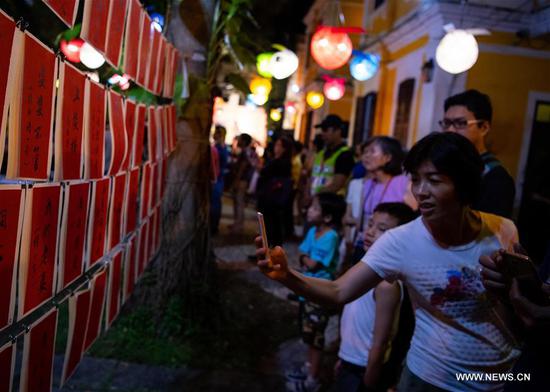 People solve lantern riddles in Macao, south China, Sept. 24, 2018. The Mid-Autumn Festival, which falls on Sept. 24 this year, is a traditional Chinese festival with a custom of family reunion. (Xinhua/Cheong Kam Ka)