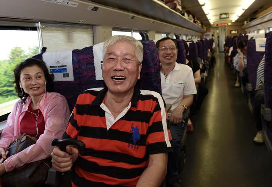 Yang Jinliang (center), 85, of Hong Kong, heads home on the first highspeed train from Fuzhou to Hong Kong on Sunday after visiting relatives in Fujian province. (Photo: Xinhua/Zhang Guojun)