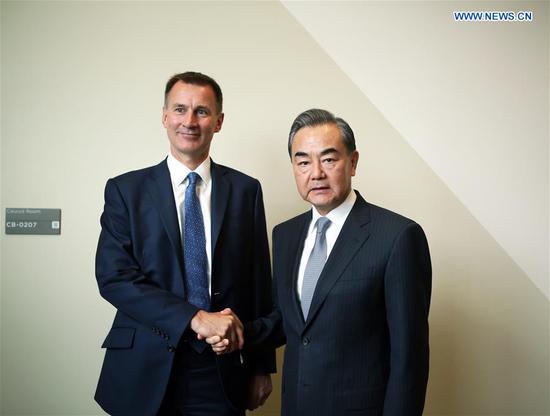 Chinese State Councilor and Foreign Minister Wang Yi (R) shakes hands with British Foreign Secretary Jeremy Hunt during their meeting at the United Nations headquarters in New York, on Sept. 24, 2018. (Xinhua/Qin Lang)