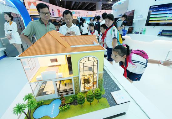 Visitors look at a model of a smart home at an industry expo in Guangzhou, capital of Guangdong Province. (Photo provided to China Daily)