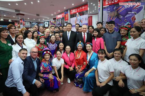 Chinese President Xi Jinping and Russian President Vladimir Putin pose for photos with youths from China and Russia and faculty representatives as they visit the All-Russian Children's Center 