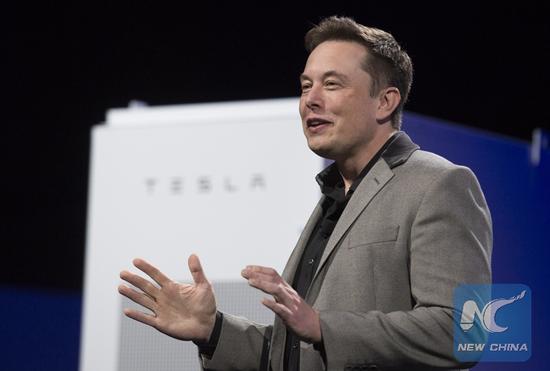 Elon Musk, CEO of Tesla, unveils a suit of batteries for homes, businesses, and utilities at Tesla Design Studio in Hawthorne, California, the United States, April 30, 2015. (Xinhua/Yang Lei)