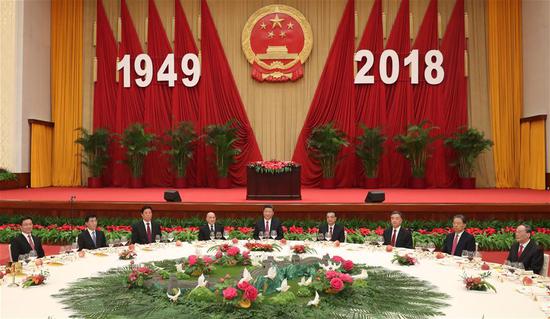Leaders of the Communist Party of China and the state Xi Jinping (C), Li Keqiang (4th R), Li Zhanshu (3rd L), Wang Yang (3rd R), Wang Huning (2nd L), Zhao Leji (2nd R), Han Zheng (1st L) and Wang Qishan (1st R) attend a reception celebrating the 69th anniversary of the founding of the People's Republic of China in Beijing, capital of China, on Sept. 30, 2018. (Xinhua/Liu Weibing)