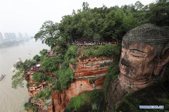 People view statue of Leshan Giant Buddha in SW China's Sichuan