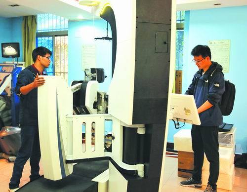 Two researchers test the lower-limb rehabilitative robot at Jingxi Hospital in Xi’an, Shaanxi Province. [Photo: sciencenet.cn]